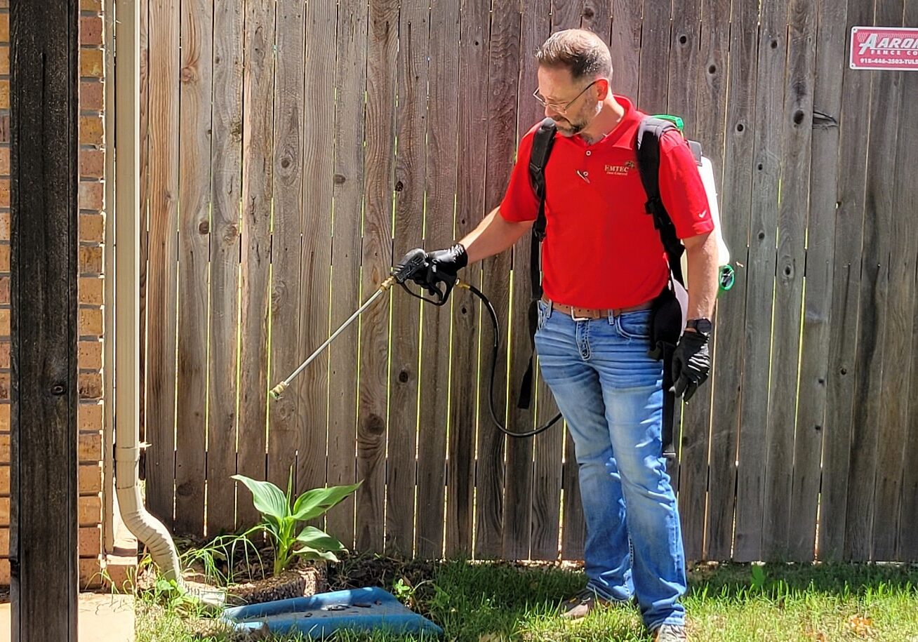 Emtec Pest Control in Tulsa - Exterminator spraying yard