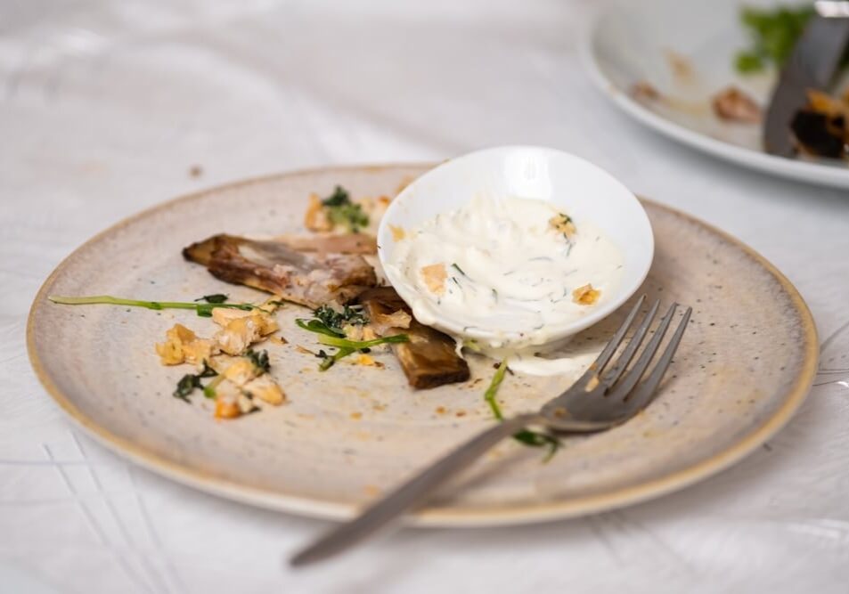 The leftover food and dirty dishes on the restaurant table