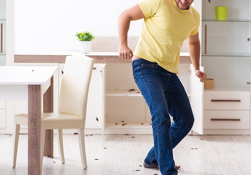 Young man and a lot of cockroaches at home
