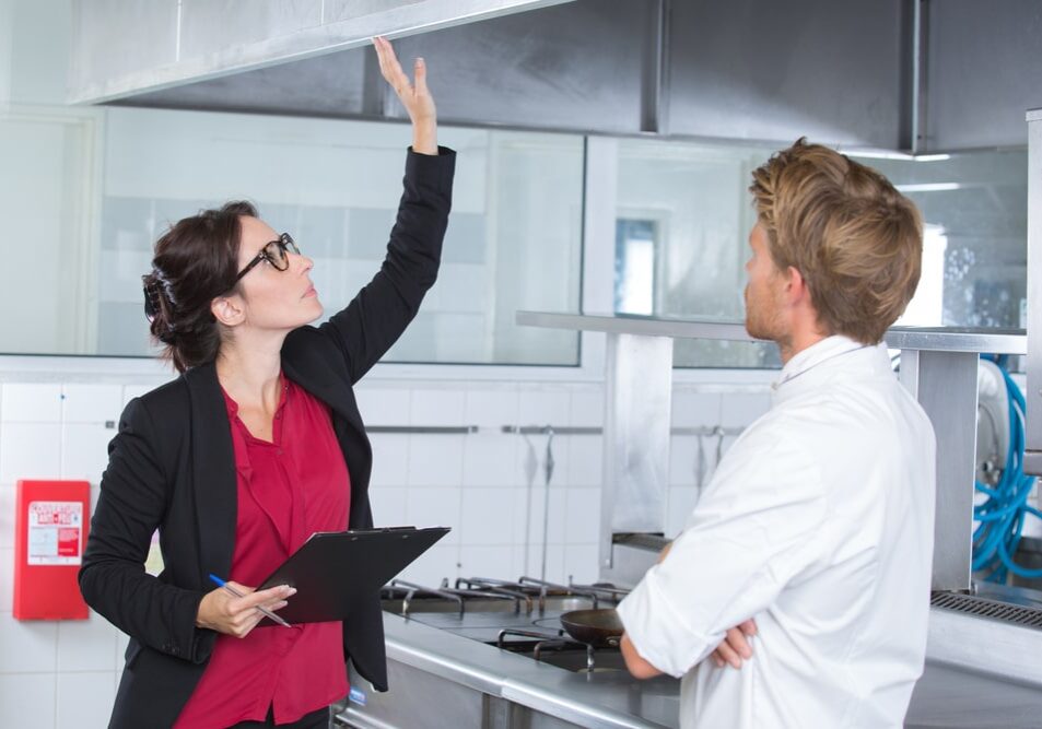 woman undergoing inspection in restaurant kitchen