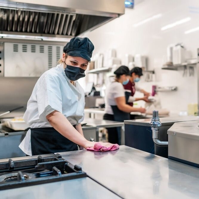 female cook cleaning her kitchen after work